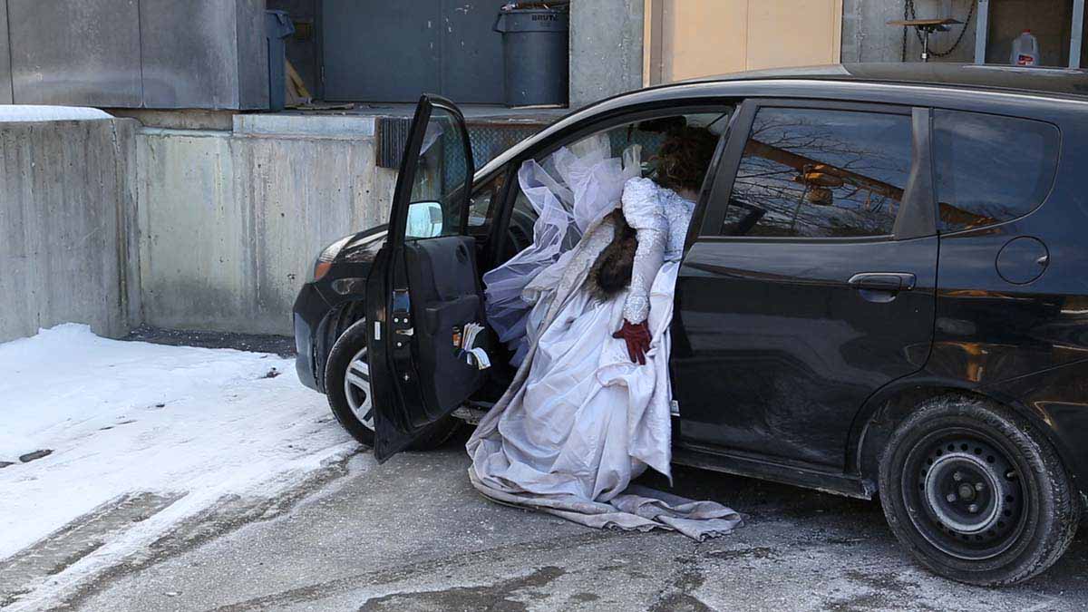 Anita Enriquez, "Docudemo: On Cars," video still, navigating everyday spaces in a wedding gown.